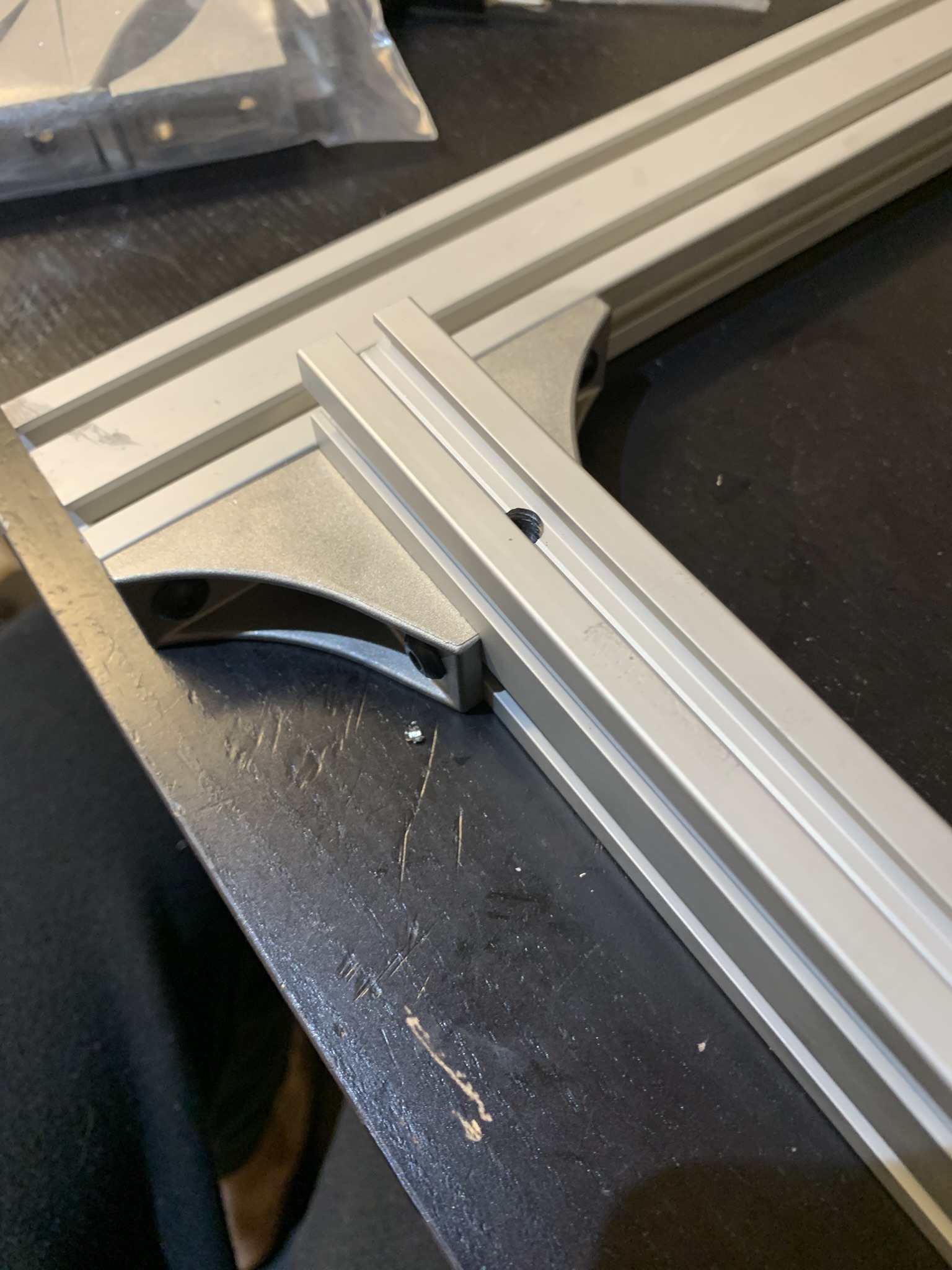 Extrusions attached at front left corner of the bed frame